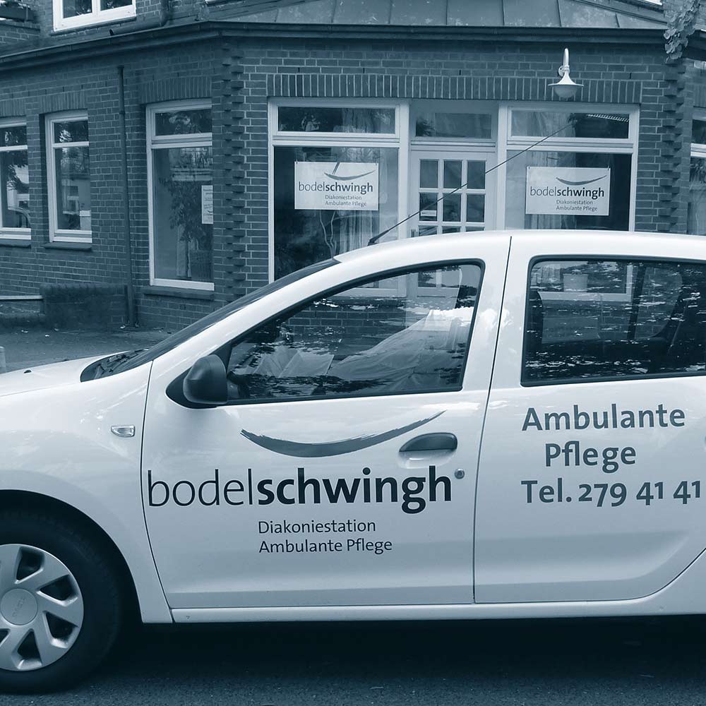 Ein Auto der Diakoniestation in Winterhude. Im Hintergrund das Gebäude der Station